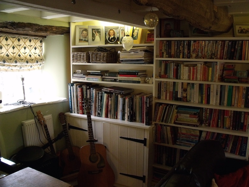 Corner view of bespoke traditional cupboards and shelves. Painted pine wood.