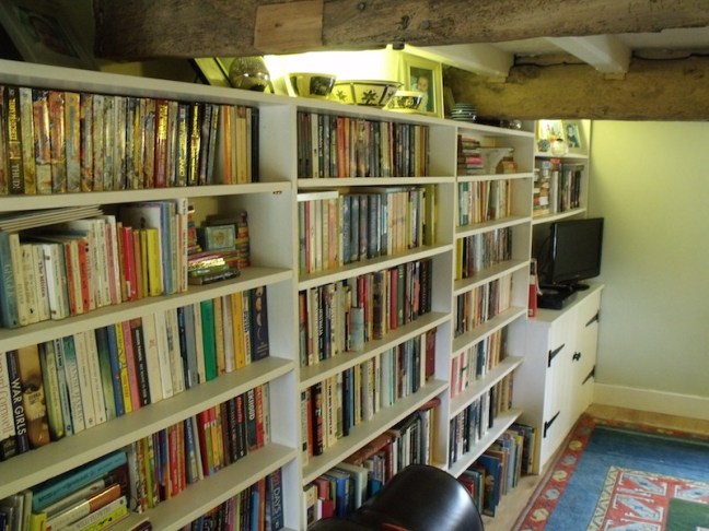 Wall to wall traditional fitted pine cupboards and shelves in 16th Century English cottage